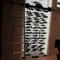 The very sturdy design and construction material used in this rolling ladder is not too heavy just so that it doesn't push down on the cable wine display. wine cellar cable wine display design and construction rolling ladder
